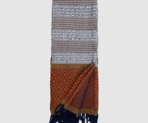 Woven scarf with gray and brown striped sections and a rust geometric block near the bottom navy fringe at the ends