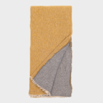 Mustard yellow throw blanket folded to reveal a grey reverse side with cream fringe along the edges