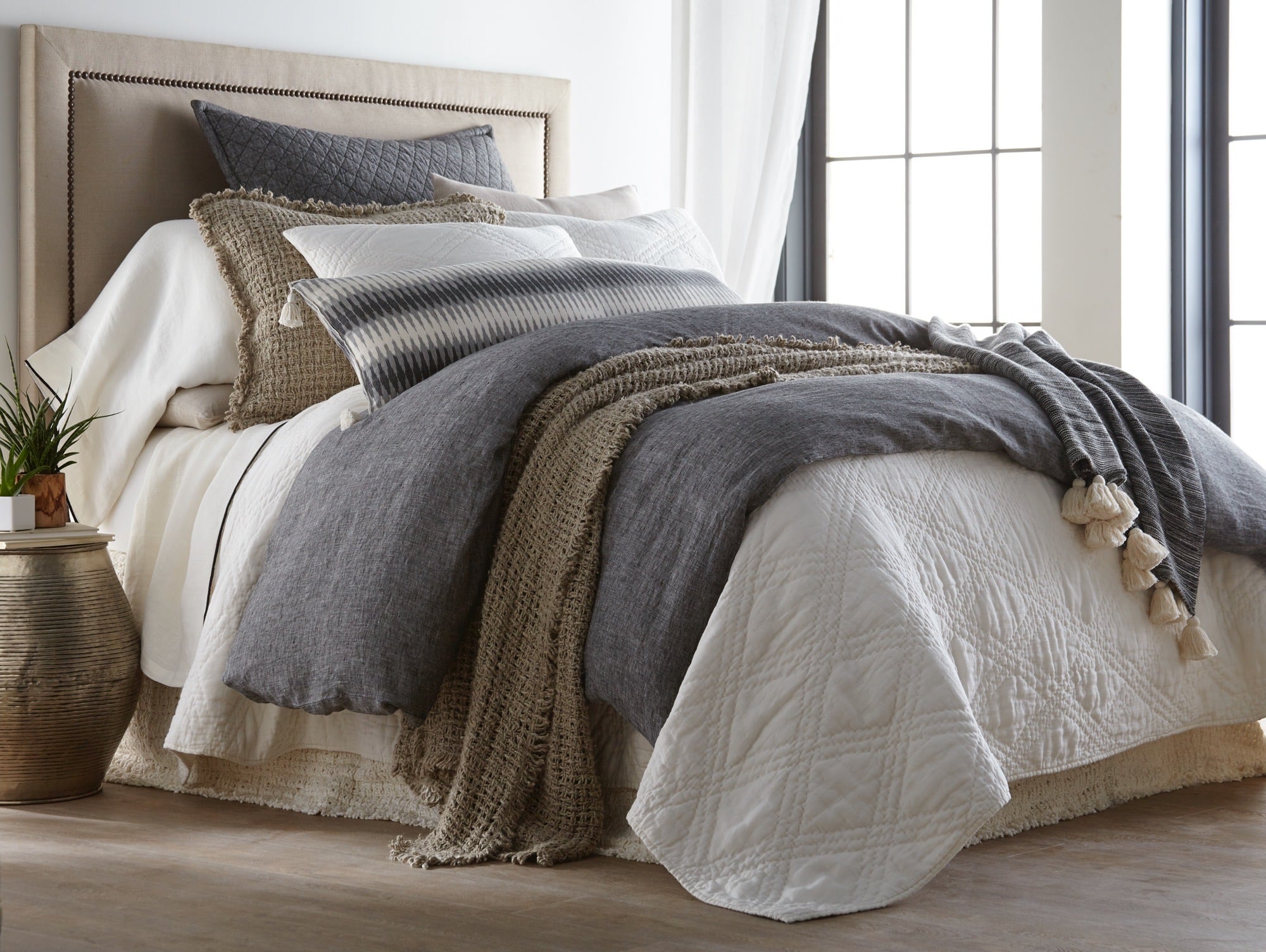 Trawick Bedres 29 | Amity Home Cozy bedroom scene with a made bed layered gray and white bedding knitted throw and a potted plant on a side table nearby