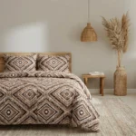 Bedroom scene with a bed covered in geometric brown and white bedding two matching pillows a wooden nightstand and a woven pendant lamp with dried pampas grass on the right