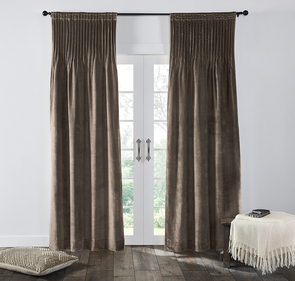 Cm15380wg | Amity Home Brown velvet curtains hung over white french doors with light filtering through a cushioned floor pillow on the left and a fringed throw with books on a small table to the right