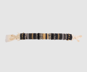 Long woven beaded bracelet with black beige and gold strands and tassels at both ends