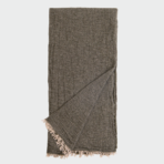 Dark brown woven scarf with beige fringe at the ends folded and laid flat on a light background