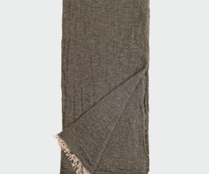 Dark brown woven scarf with beige fringe at the ends folded and laid flat on a light background