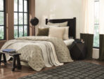 Cozy bedroom with a tufted beige quilt cream pillows and a dark wood headboard by large sunlit windows