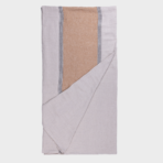 Folded throw blanket with a tan center panel and white and black striped edges on light gray fabric