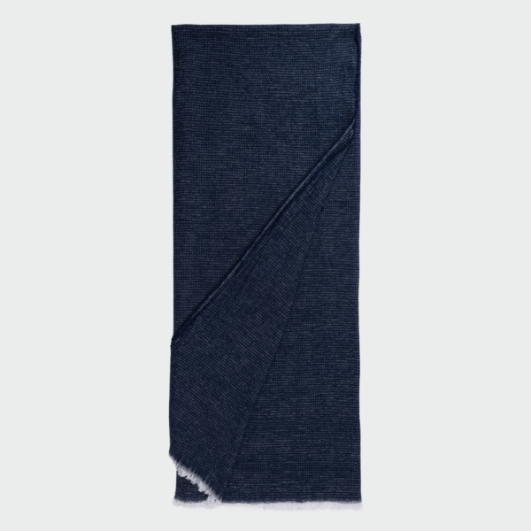 Navy blue woven scarf folded with fringed ends showing a textured knit pattern