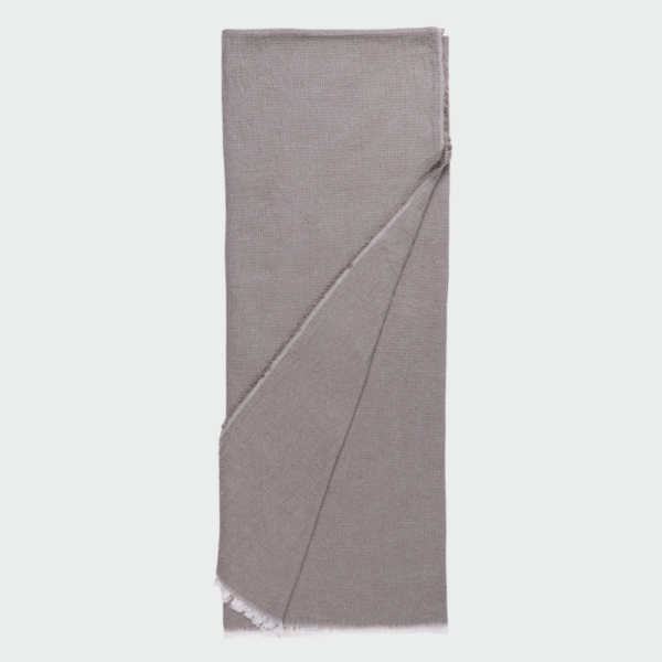 Light gray knit scarf folded flat with fringed edges visible at the bottom corner.