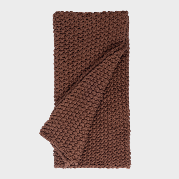 Brown chunky-knit blanket folded for display, showing thick yarn texture and warm chocolate color