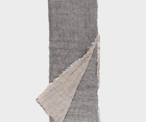 Gray woven scarf with a beige underside folded diagonally across the image fringed edges visible