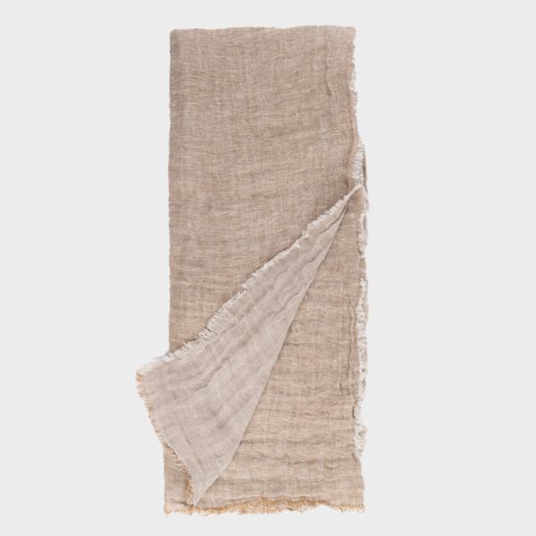 Beige linen fabric laid flat with a fringed edge; one corner folded back to show the lighter underside