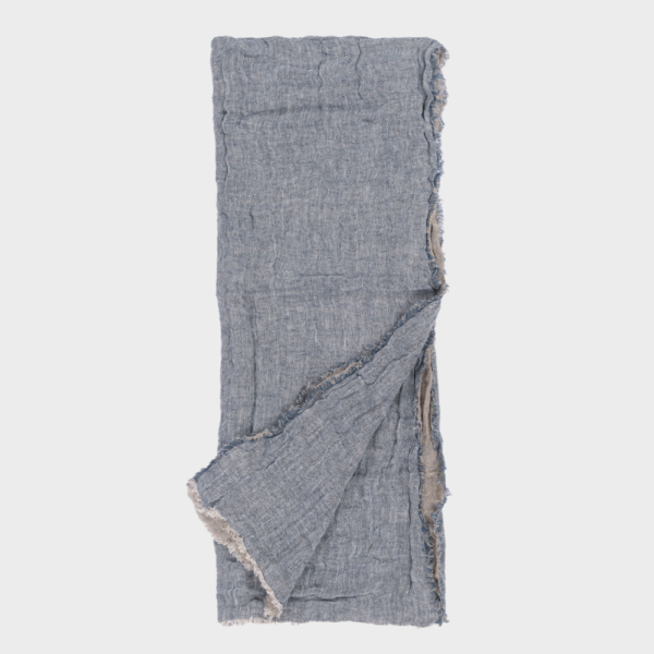 Blue-gray linen scarf with frayed edges, laid flat with one corner folded over