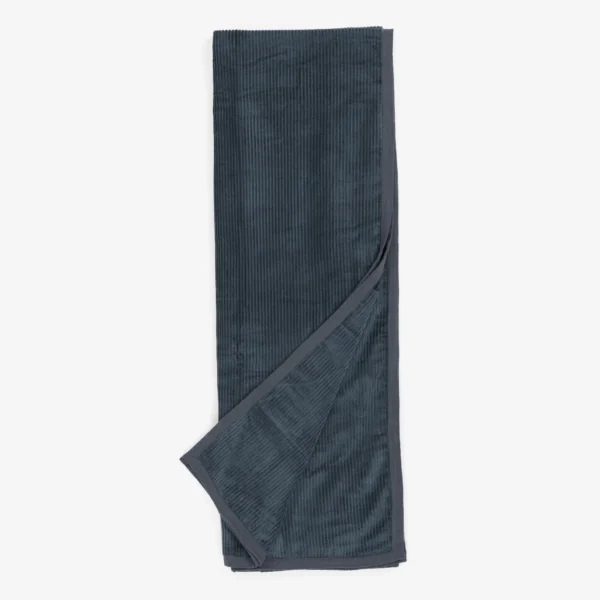 Dark blue corduroy belt laid flat with a crossed strap at the bottom