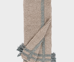 Beige woven scarf with blue gray stripes and fringed ends folded diagonally across the image