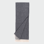 Dark gray woven scarf with light fringed ends folded with one corner pulled over