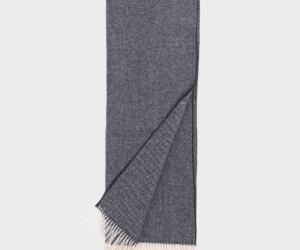 Dark gray woven scarf with light fringed ends folded with one corner pulled over