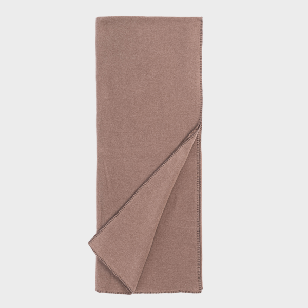 Dusty rose blanket folded, showing stitched edge along the border.