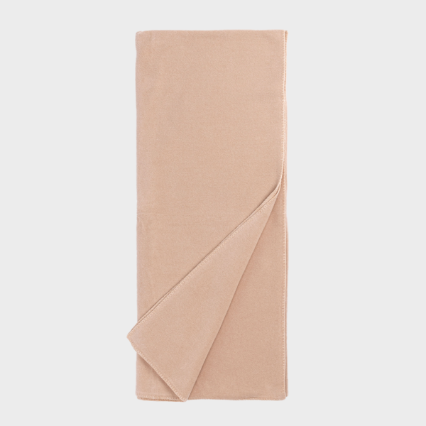 Beige folded throw blanket with a corner turned over, showing soft fabric edge