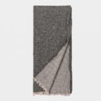 Folded dark gray scarf with fringed edges against a white background