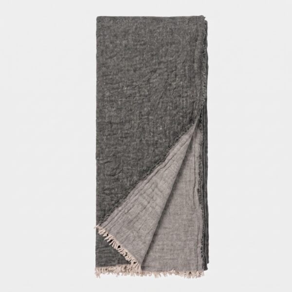 Folded dark gray scarf with fringed edges against a white background.