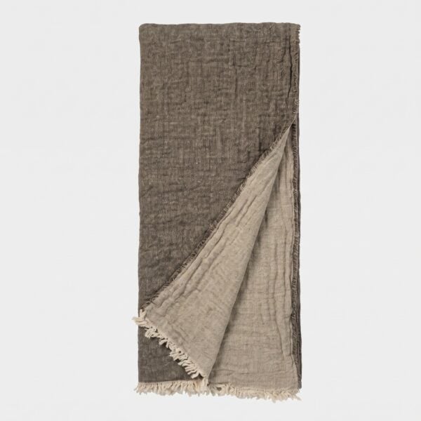 Brown woven scarf with light fringe along the bottom edge, hanging vertically against a pale background.