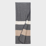 Folded grey throw blanket with white and beige stripes showing a textured herringbone pattern