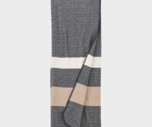 Folded grey throw blanket with white and beige stripes showing a textured herringbone pattern