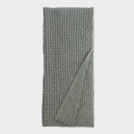 Gray knit scarf folded with a corner turned up showing chunky rib stitch texture