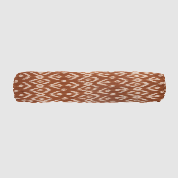 Rolled fabric with a brown and white ikat pattern on a light gray background.