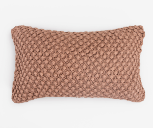Dusty pink rectangular knitted throw pillow with chunky crochet texture on a white background
