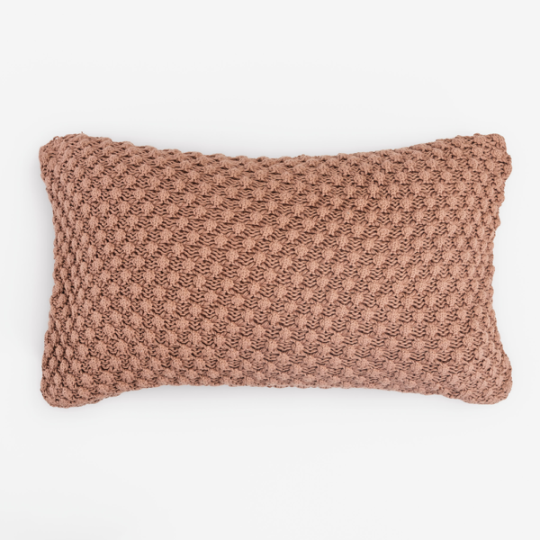 Dusty pink rectangular knitted throw pillow with chunky crochet texture on a white background