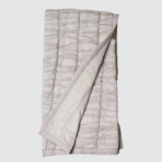 Light gray quilted blanket folded with vertical channel stitching visible throughout