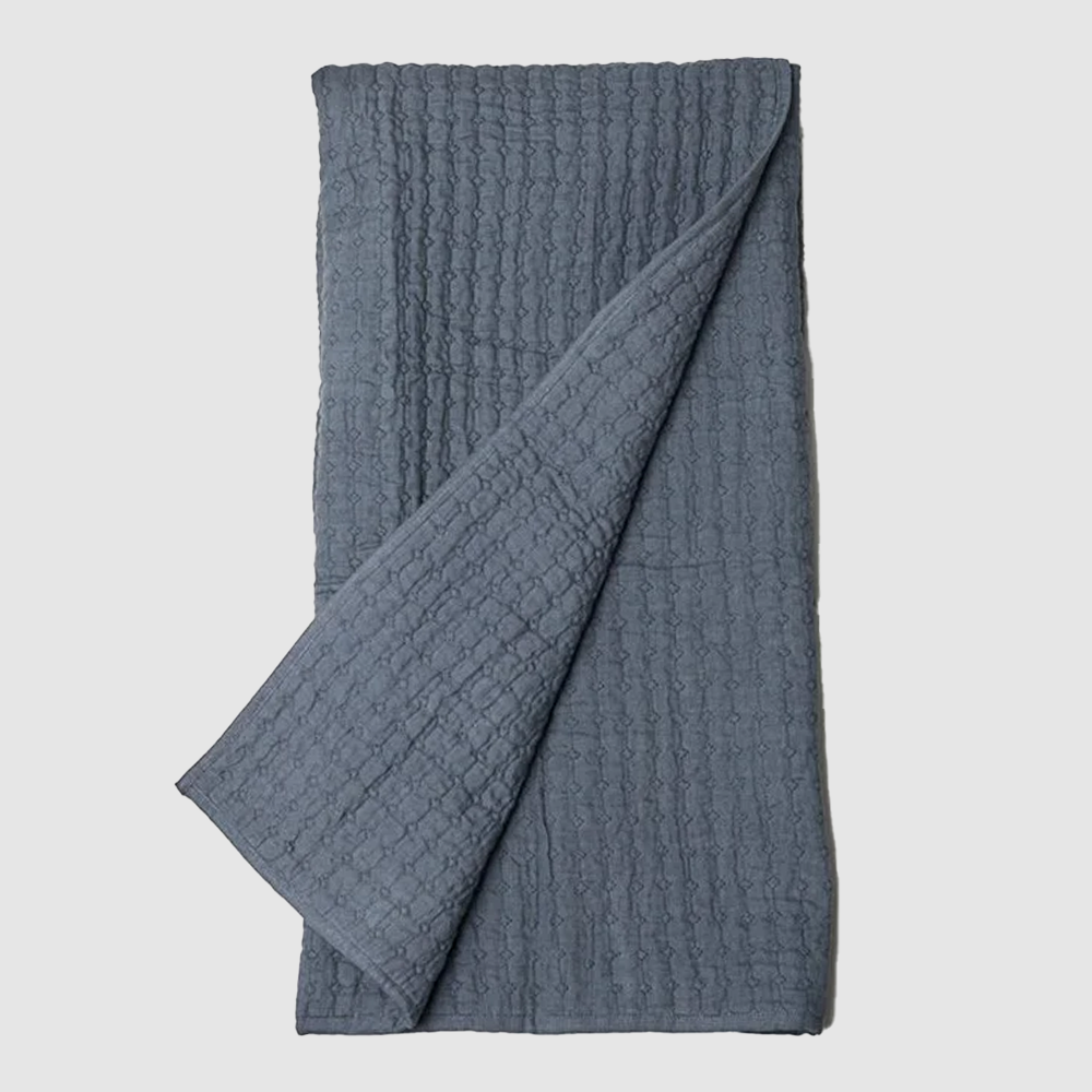Bc603b | Amity Home Blue gray waffle knit blanket folded with one corner pulled over the edge on a light background