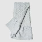 Light gray quilted blanket folded with a diamond stitch pattern