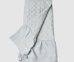 Light gray quilted blanket folded with a diamond stitch pattern