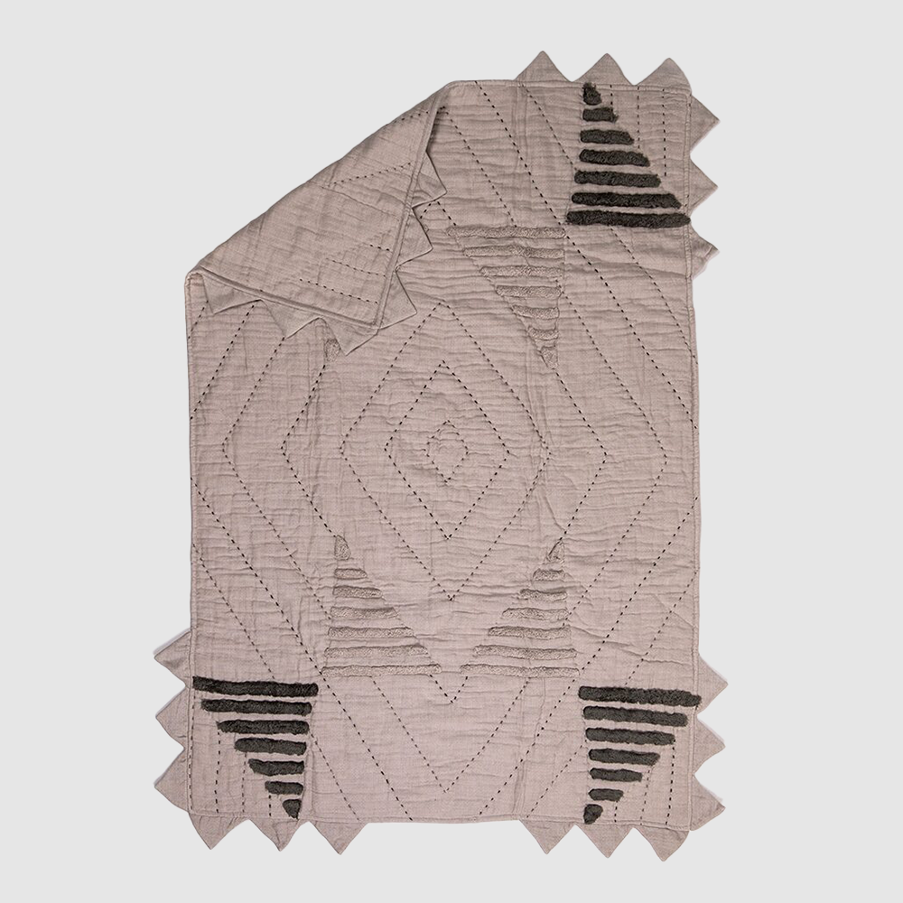 Cc1009b | Amity Home Soft pink quilt with a diamond quilted pattern jagged fringe edges along the borders and black stepped chevron motifs in the corners