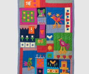 Colorful patchwork quilt with whimsical birds hearts and flowers in bright blocks and a blue checked border