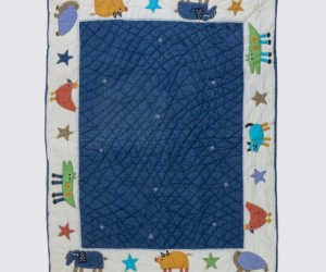 Childrens quilt with a blue inner field and an outer white border featuring colorful animal shapes and stars around the edges