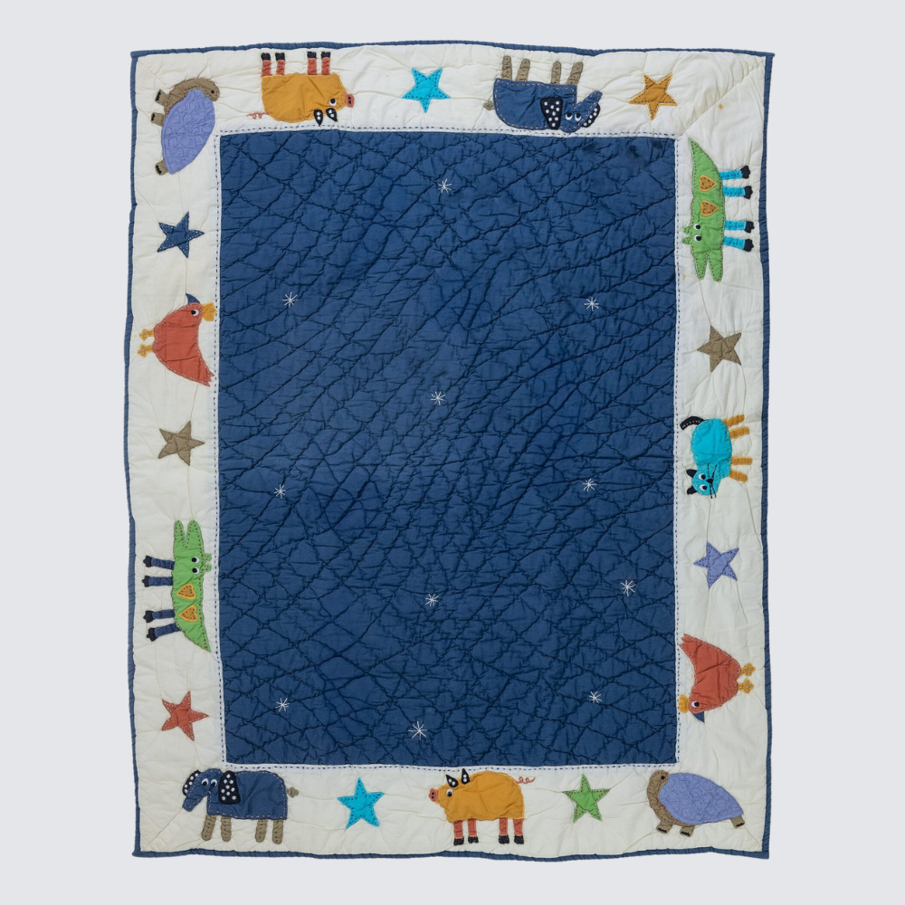 Cc256b | Amity Home Childrens quilt with a blue inner field and an outer white border featuring colorful animal shapes and stars around the edges