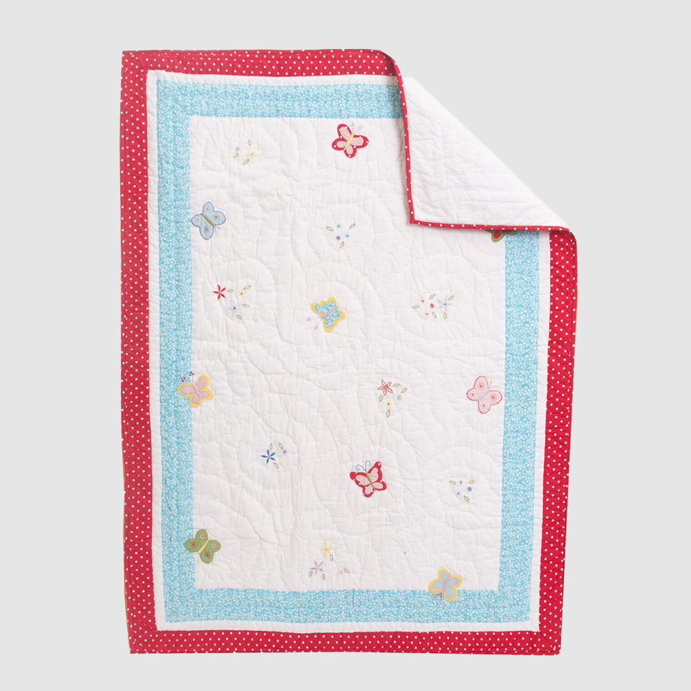 Cc757b | Amity Home Quilted blanket with white center butterfly pattern and red and blue polka dot borders folded at corner for display