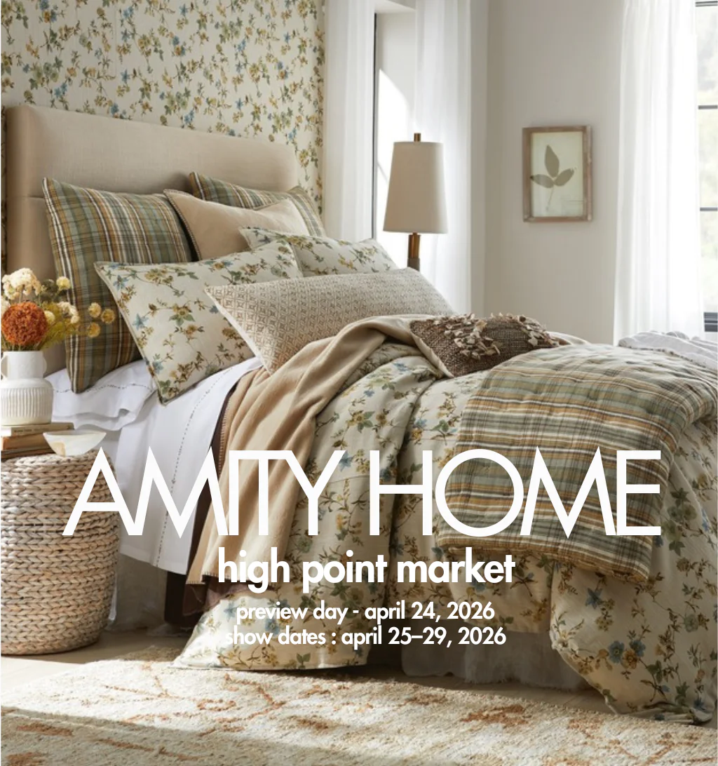 Cozy floral bedroom with a bed pillows and a large white text overlay for amity homes high point market with dates aprile 2429 2026