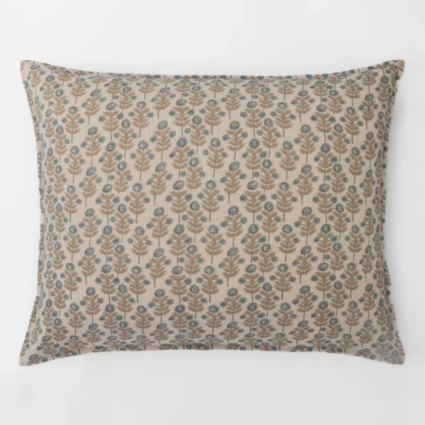 Decorative beige pillow with blue floral pattern against a white background