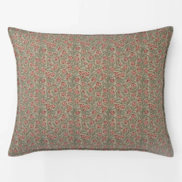 Patterned decorative pillow with pink flowers and green leaves on a beige background.