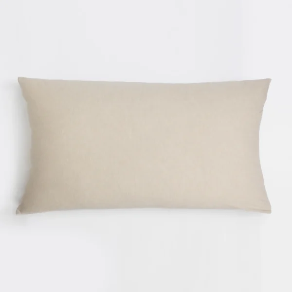Beige rectangular pillow resting on a white background fabric appears linen textured