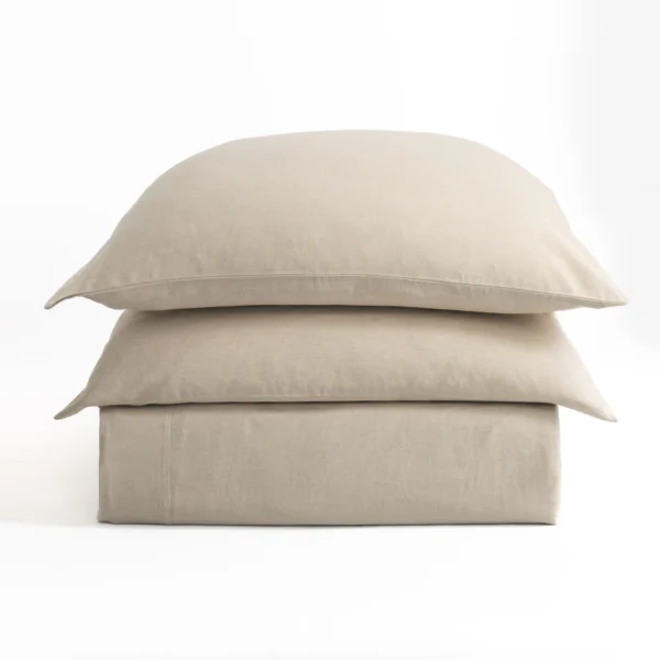 Three beige pillows stacked on a white background.