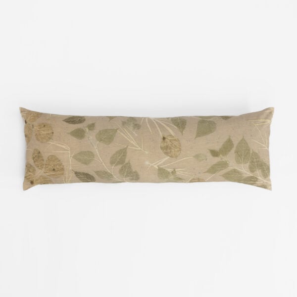 Beige decorative pillow with a green leafy botanical pattern against a white background.