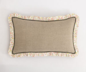 Beige fabric cushion with a floral ruffle trim against a white background