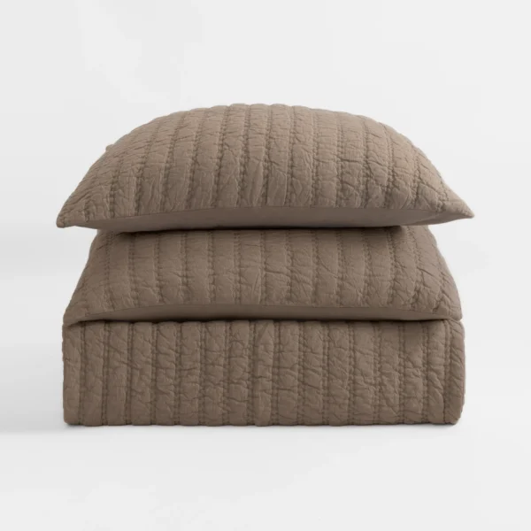 Stack of two taupe quilted pillows with a textured stitched pattern against a light background