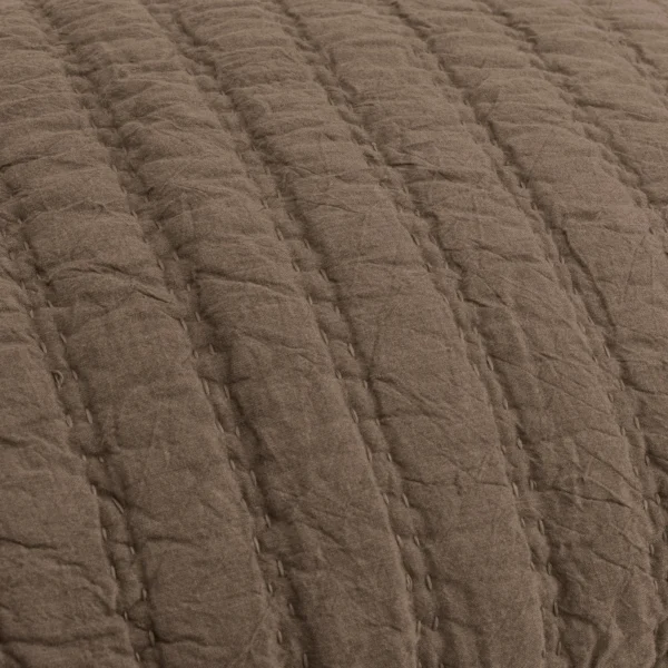 Close up of brown quilted fabric with a grid of stitched seams creating padded squares to convey a soft textile texture