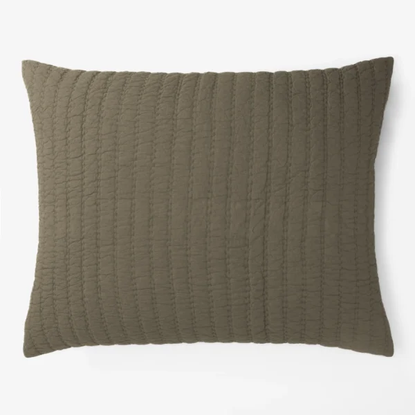 Close up of a brown quilted cushion with vertical stitching on a white background